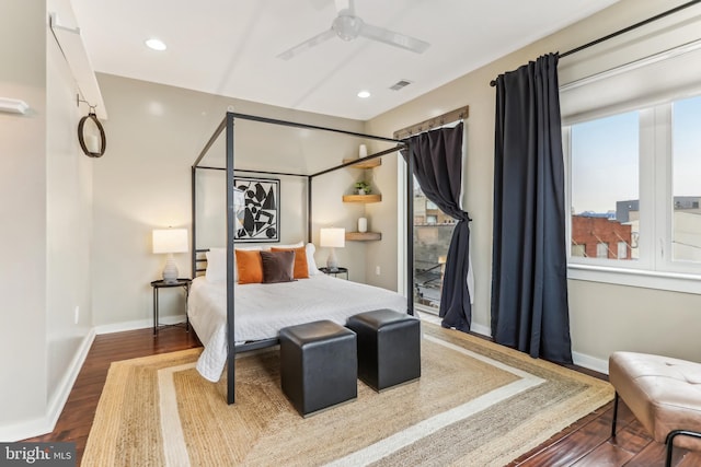 bedroom with visible vents, baseboards, and wood finished floors