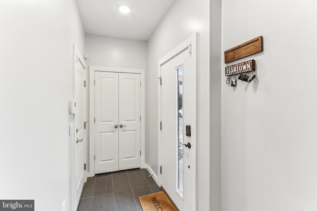 entryway featuring dark tile patterned floors