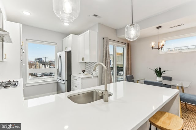 kitchen featuring a sink, visible vents, a healthy amount of sunlight, white cabinets, and appliances with stainless steel finishes