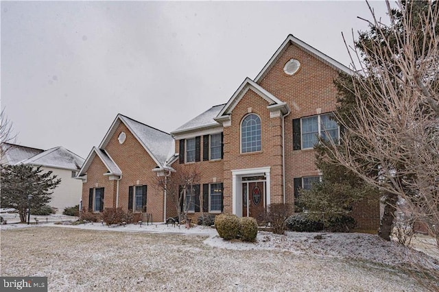 colonial house featuring brick siding