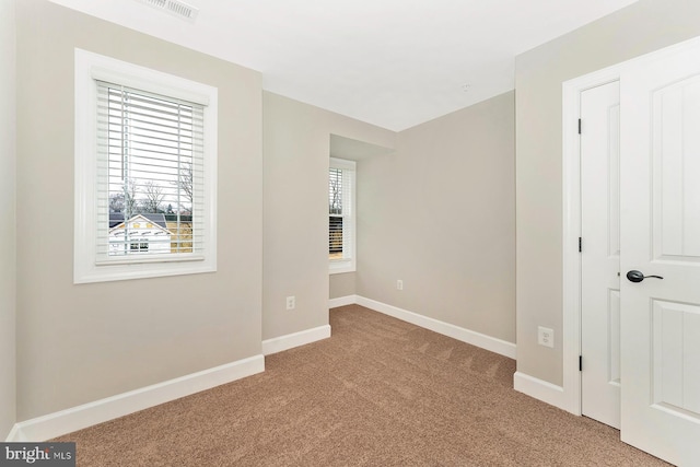 unfurnished bedroom featuring carpet, visible vents, and baseboards