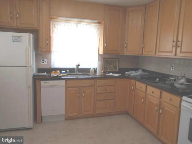 kitchen featuring white appliances, dark countertops, a sink, and decorative backsplash