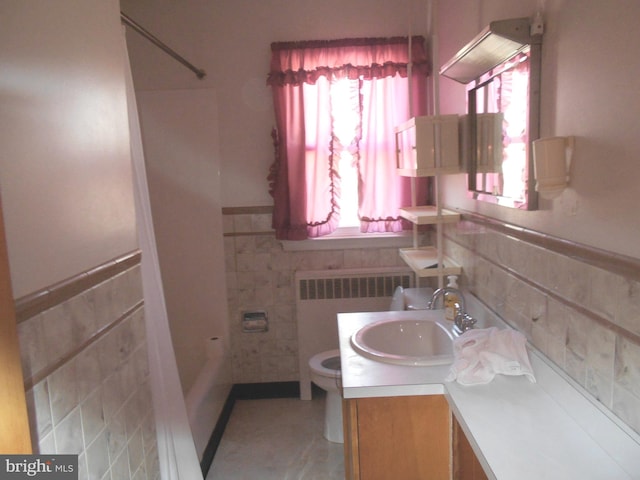 full bathroom featuring toilet, vanity, tile walls, a shower, and radiator heating unit