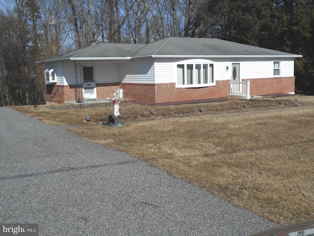 ranch-style home with brick siding and a front lawn