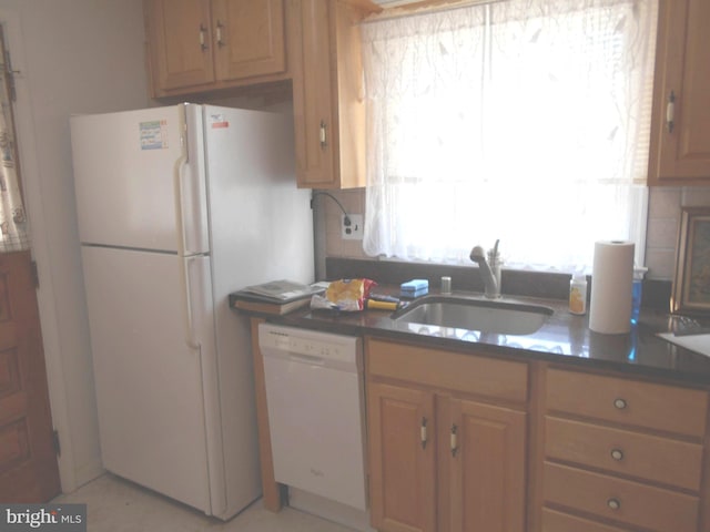 kitchen with tasteful backsplash, dark countertops, white appliances, and a sink