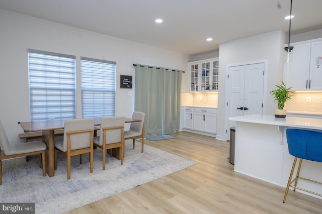 dining room with light wood-type flooring and recessed lighting