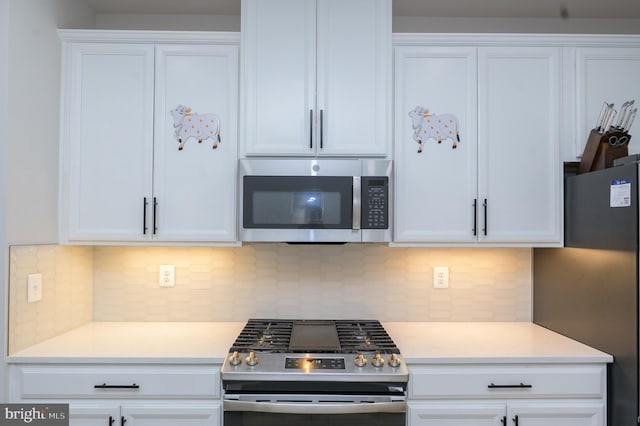 kitchen featuring white cabinets, appliances with stainless steel finishes, and light countertops