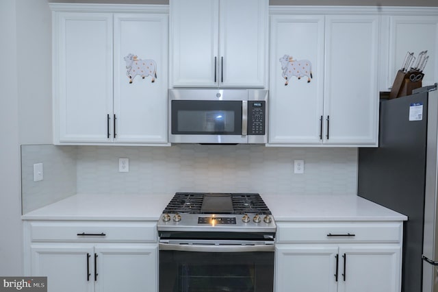 kitchen with stainless steel appliances, white cabinets, light countertops, and decorative backsplash