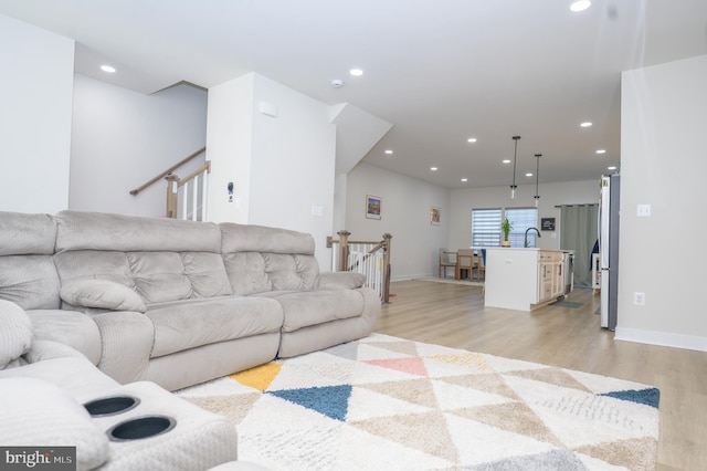 living area featuring light wood-type flooring, recessed lighting, and baseboards