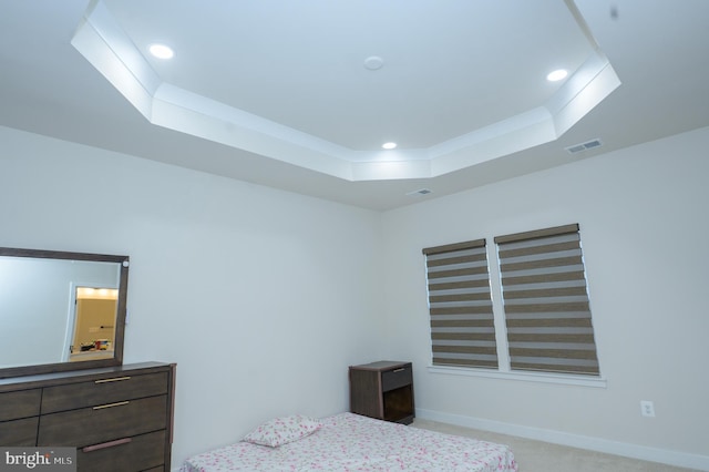 bedroom featuring light carpet, visible vents, a tray ceiling, and recessed lighting