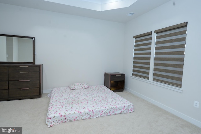 bedroom featuring a skylight, baseboards, and light colored carpet