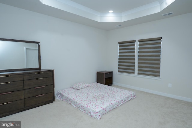 bedroom featuring light carpet, a raised ceiling, visible vents, and baseboards