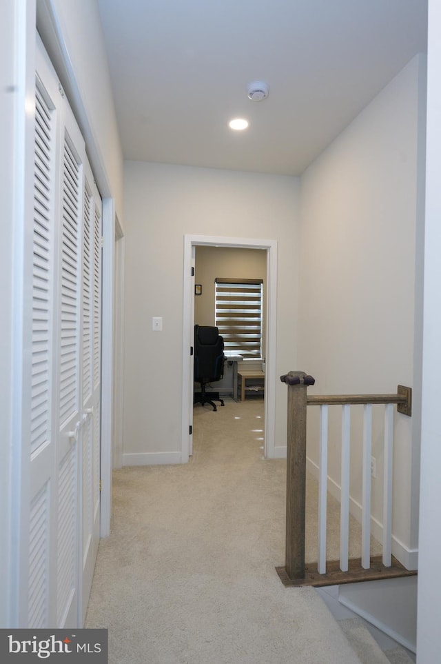 hall with baseboards, recessed lighting, and light colored carpet