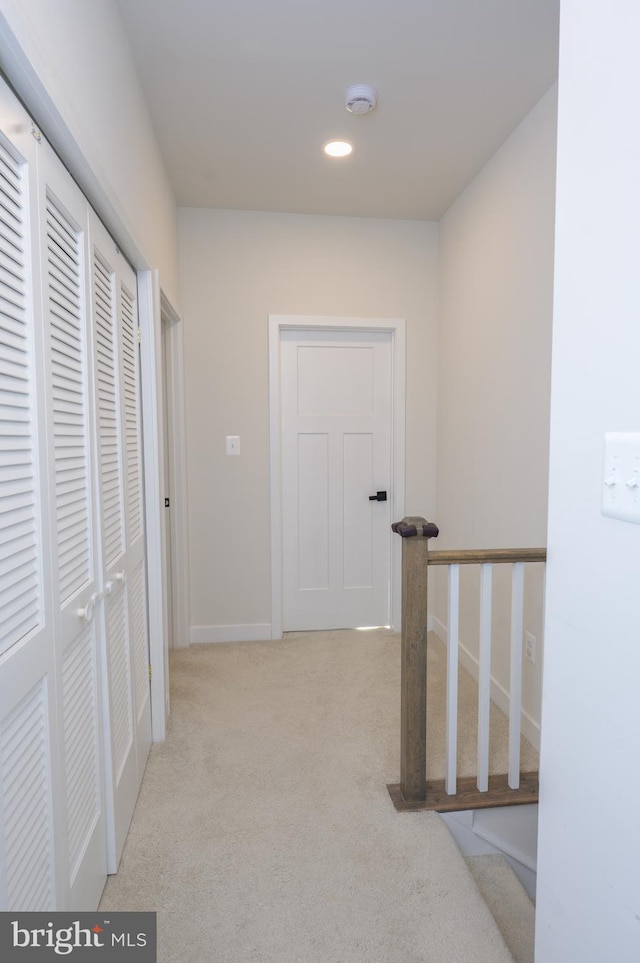 corridor with recessed lighting, light colored carpet, and baseboards