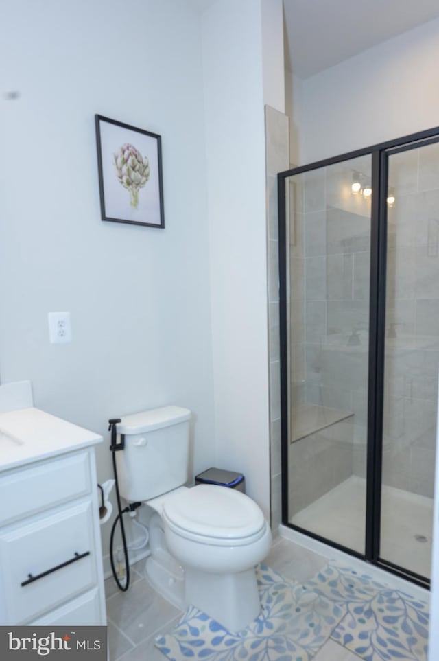 bathroom with a stall shower, tile patterned flooring, vanity, and toilet