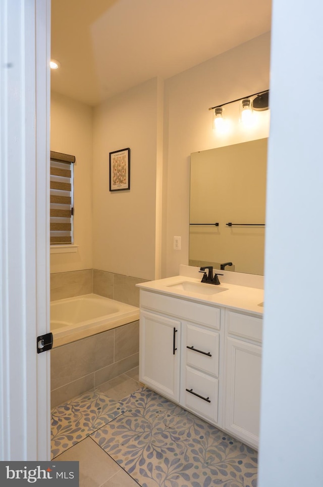 full bath with a garden tub, vanity, and tile patterned floors