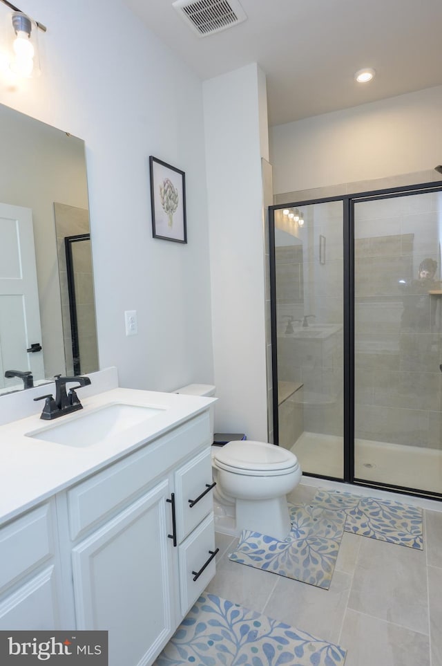 full bath featuring tile patterned flooring, toilet, vanity, visible vents, and a shower stall