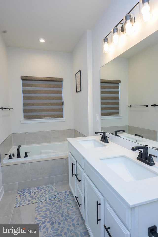 full bathroom featuring a bath, double vanity, a sink, and tile patterned floors