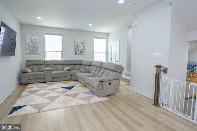 living room featuring a healthy amount of sunlight, light wood-style flooring, and baseboards