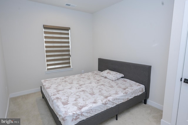 bedroom with light colored carpet, visible vents, and baseboards