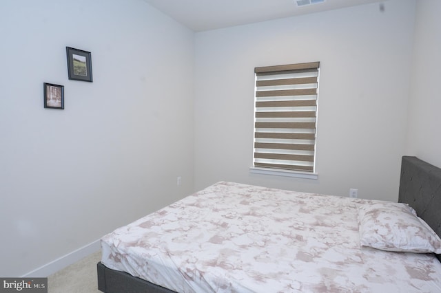 bedroom with light carpet, visible vents, and baseboards