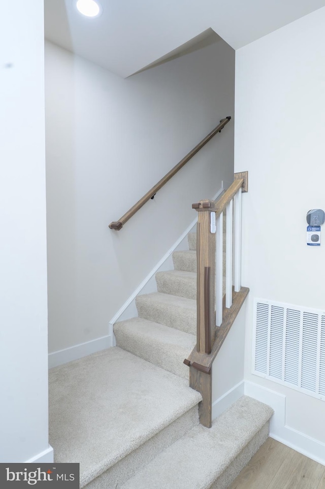 stairway with baseboards and visible vents