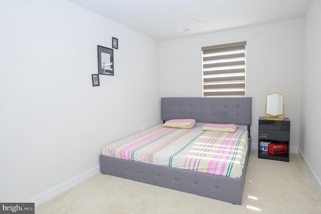 bedroom featuring light carpet and baseboards