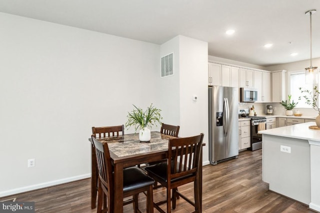 dining room with dark wood-type flooring, recessed lighting, visible vents, and baseboards