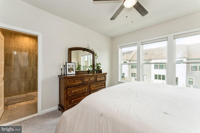 carpeted bedroom featuring ensuite bathroom, a ceiling fan, and baseboards