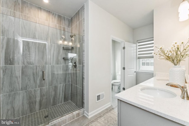 full bathroom with toilet, a sink, visible vents, a shower stall, and double vanity