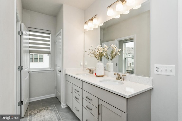 bathroom with double vanity, a sink, and a healthy amount of sunlight