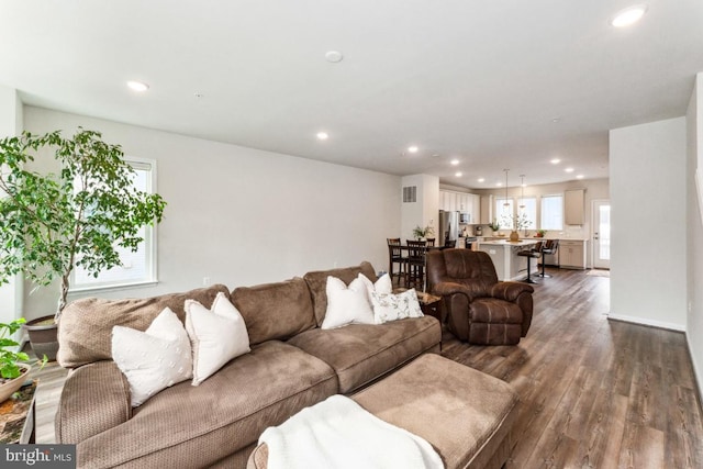 living room featuring recessed lighting, dark wood-style flooring, and visible vents