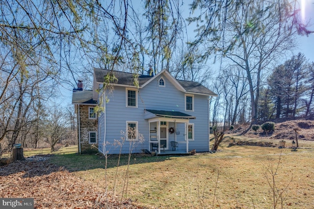 521 Brightfield Rd, Lutherville Timonium, MD 21093 - view of front of house with a chimney, covered porch, a front lawn, and stone siding