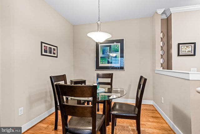 dining space with baseboards and wood finished floors