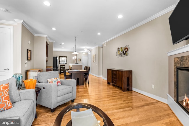 living area featuring light wood-style floors, recessed lighting, a fireplace, and baseboards