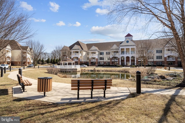 surrounding community with a lawn and a water view