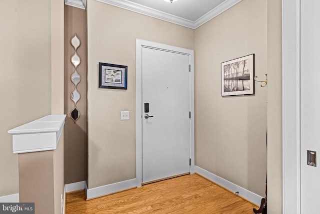 entryway with crown molding, light wood-style flooring, and baseboards