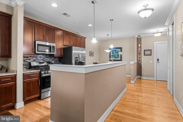 kitchen with a center island with sink, visible vents, decorative backsplash, appliances with stainless steel finishes, and light wood-type flooring