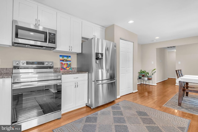 603 N York Rd, Sterling, VA 20164 - kitchen featuring stainless steel appliances, white cabinetry, light wood finished floors, recessed lighting, and dark stone countertops