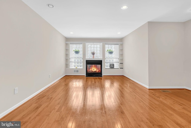 603 N York Rd, Sterling, VA 20164 - unfurnished living room with light wood-style floors, a multi sided fireplace, baseboards, built in features, and recessed lighting