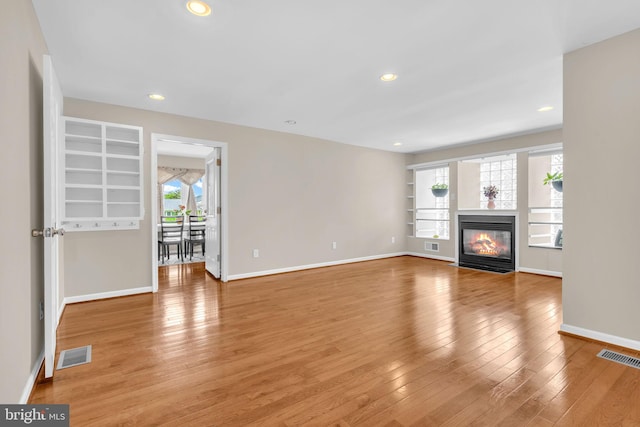 603 N York Rd, Sterling, VA 20164 - unfurnished living room with light wood-style floors, a glass covered fireplace, baseboards, built in features, and recessed lighting
