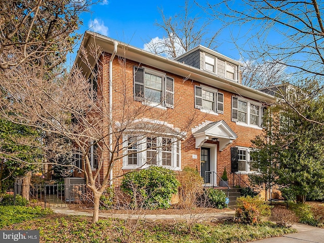 view of front of property featuring brick siding and fence