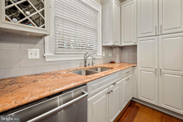 kitchen featuring dark wood-style flooring, tasteful backsplash, white cabinets, a sink, and dishwasher