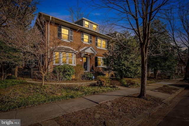 view of front of house featuring brick siding and fence