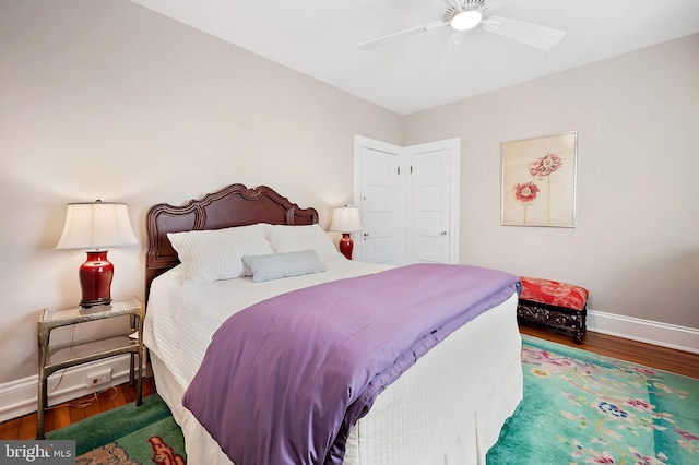 bedroom with ceiling fan, baseboards, and wood finished floors