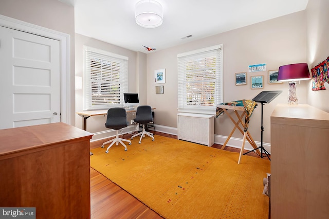 home office with visible vents, baseboards, and wood finished floors