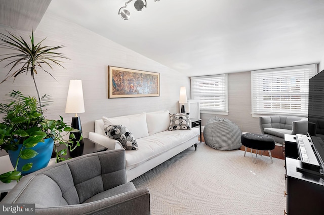 carpeted living area with vaulted ceiling