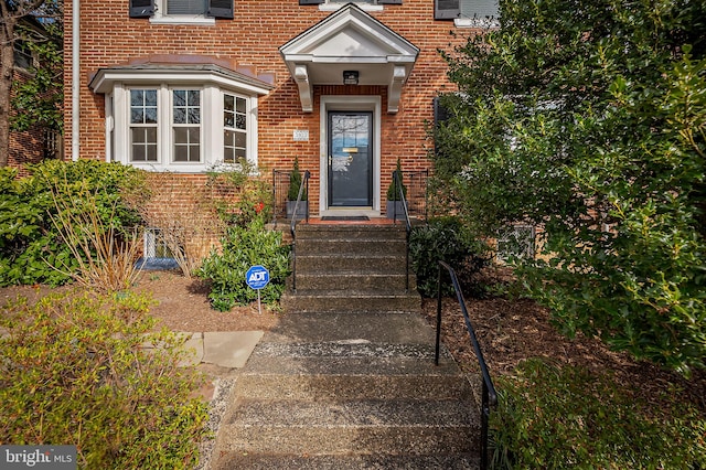 view of exterior entry featuring brick siding