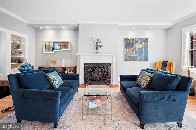 living room with a fireplace with flush hearth, recessed lighting, wood finished floors, and crown molding