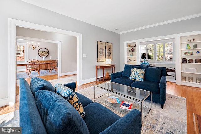 living area featuring baseboards, crown molding, built in features, and wood finished floors